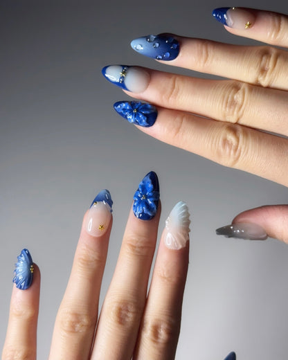 Close-up of hands with blue nail art on a gray background